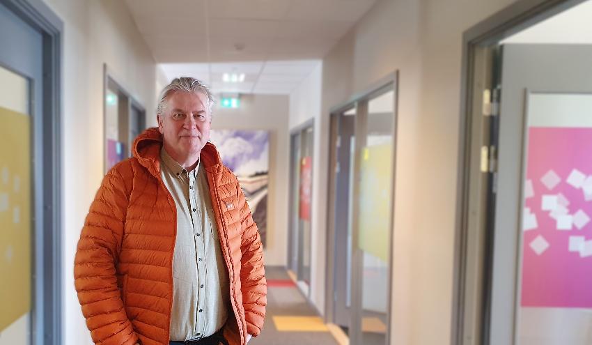 Bildet viser prosjektleder Rune Wara. Han har på seg en oransje boblejakke og hvit skjorte. Han står inne i de nyoppussede lokalene. 